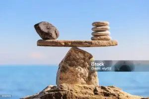 Eine ausbalancierte Waage aus Steinen als Symbol für körperliches Gleichgewicht und ATSI-Therapie bei Medwell Thun.